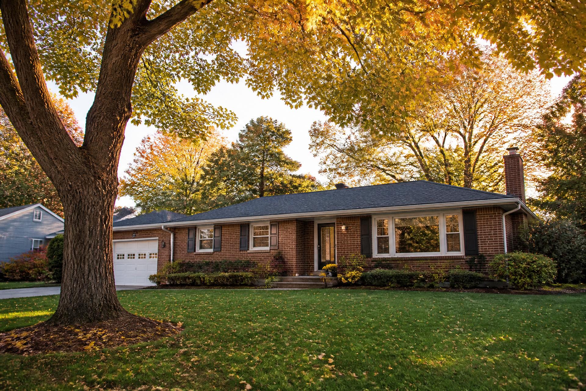 Brick ranch home on a tree lined street in West Michigan in autumn